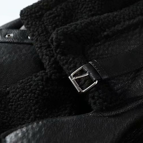 Close-up of a black leather jacket with a buckle detail