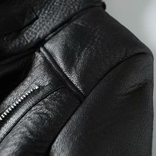 Close-up of a black leather jacket with a zipper on a blurred background