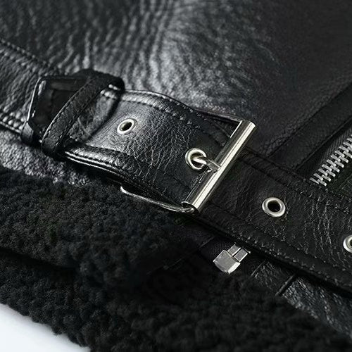 Close-up of a black leather jacket with a belt and zipper details.