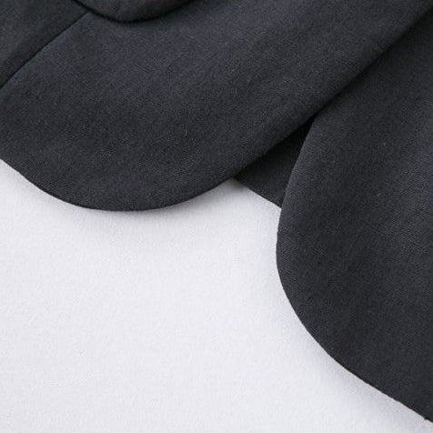 Three close-up detail shots of a black fabric garment, showing a buttoned lapel, a pocket seam, and a folded cuff on a light background.