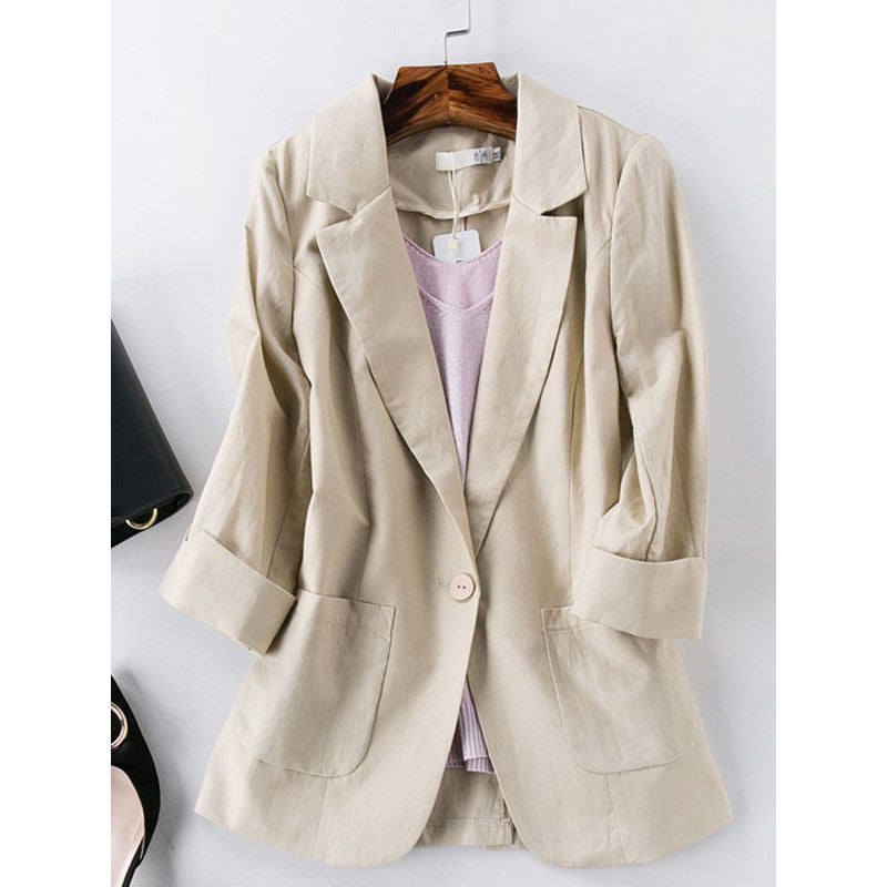 Beige blazer on a hanger against a white background