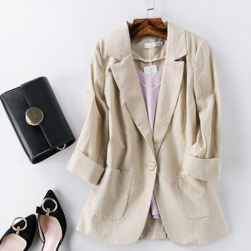 Beige blazer on a hanger with a black clutch and shoes on a white background