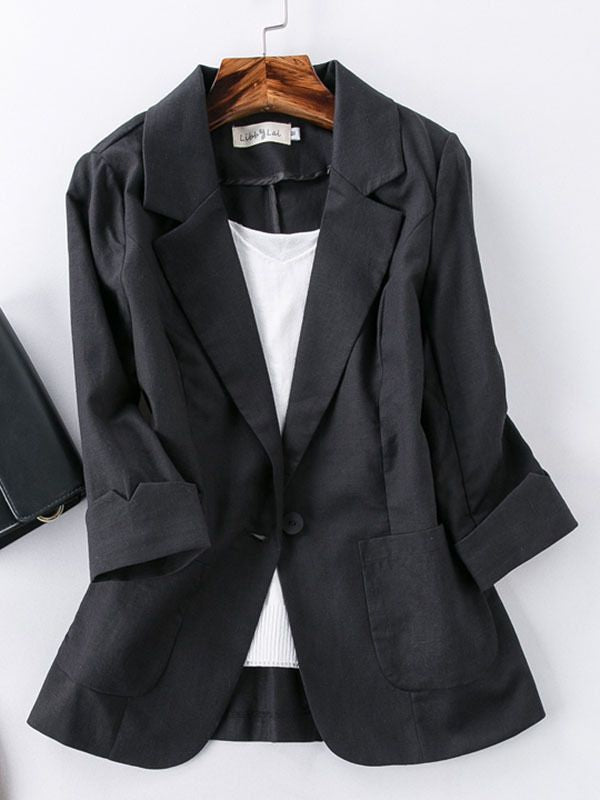 Black blazer on a hanger against a white background