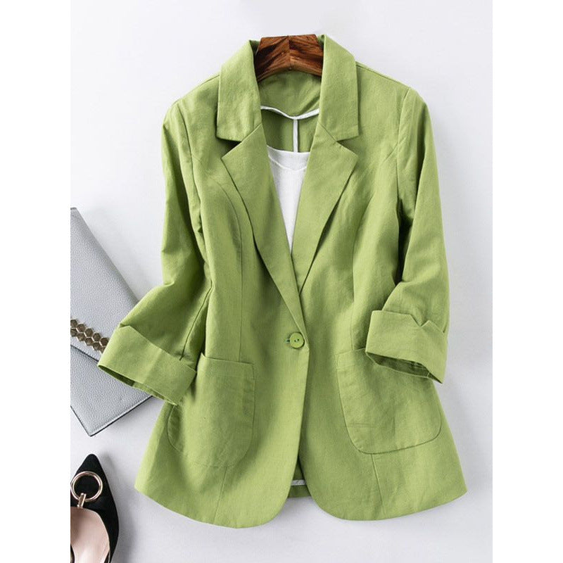 Green blazer on a hanger against a white background