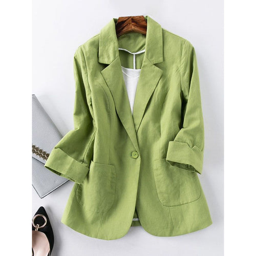Green blazer on a hanger against a white background