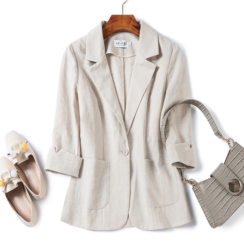Beige blazer on a hanger with shoes and handbag on a white background